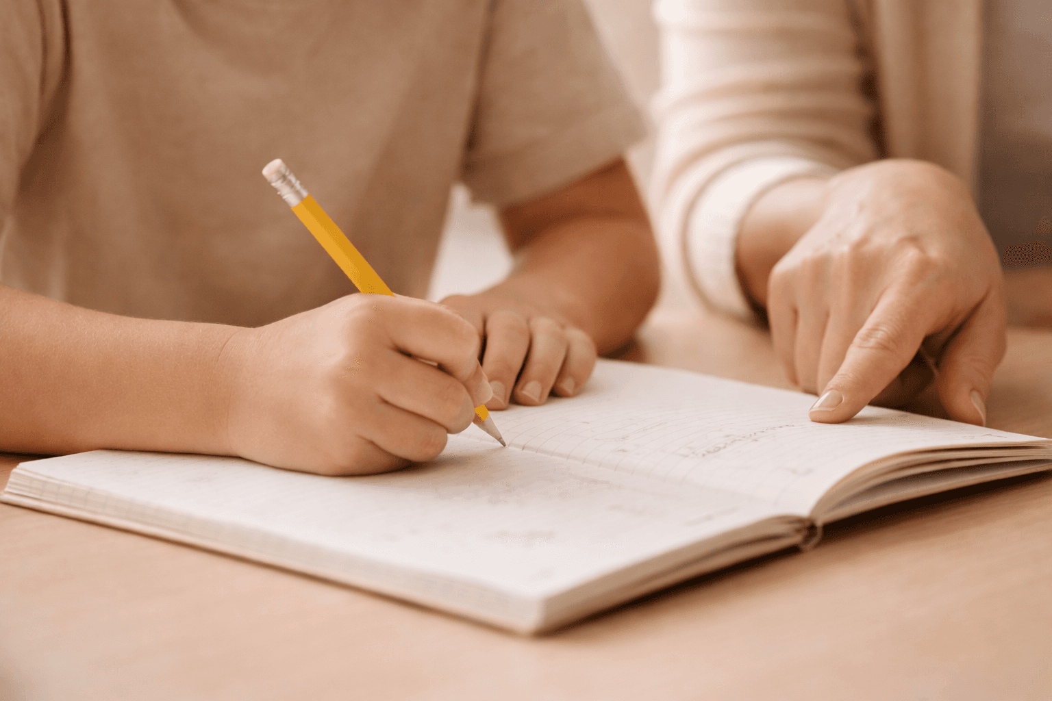 Child writing with a pencil during a tutoring session